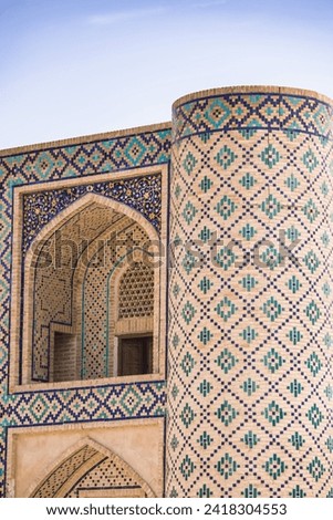 Element of the facade of a brick madrasah with mosaic and majolica cladding in the ancient city of Bukhara in Uzbekistan, architecture in oriental style