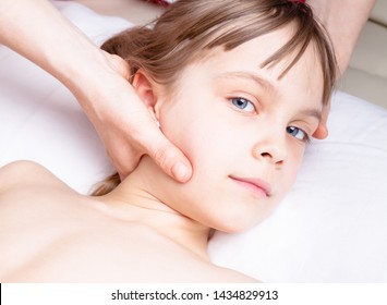 Elementary Age Girl's Neck Being Manipulated By Osteopathic Or Chiropractic Manual Therapist In A Pediatric Clinic