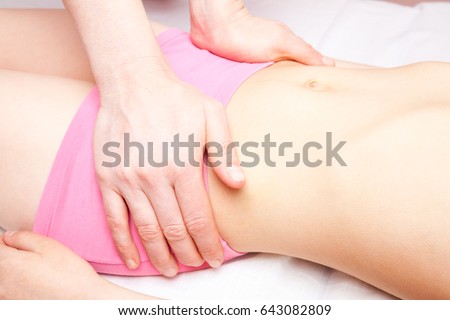 Elementary age girl's pelvis being manipulated by an osteopath - an alternative medicine treatment