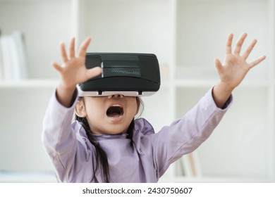 An elementary aged girl uses a virtual reality headset to enhance learning experience with excitement. Marketing for VR products, educational technology content. - Powered by Shutterstock