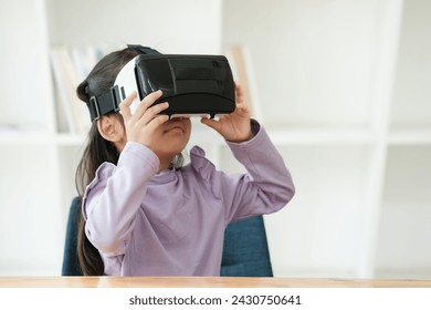 An elementary aged girl uses a virtual reality headset to enhance learning experience with excitement. Marketing for VR products, educational technology content. - Powered by Shutterstock