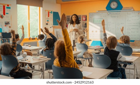 Elementary Classroom with Diverse Children Listening to the Teacher Asking a Question. Everyone Raising Hands in Order to Provide a Correct Answer. Bright Kids in School Learning Exact Sciences - Powered by Shutterstock