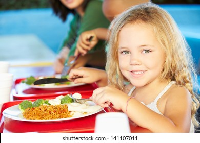 Elementary Pupils Enjoying Healthy Lunch In Cafeteria