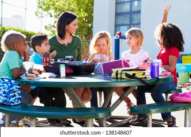 Elementary Pupils And Teacher Eating Lunch