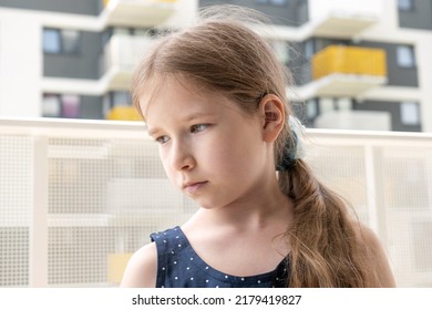 Elementary School Age Girl, Calm Caucasian Child Outdoors Casual Portrait, Face Closeup, Detail, One Person Looking To The Side, Calm Sad Expression. Real Estate, Residential Area In The Background