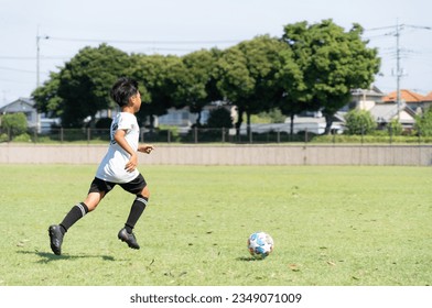 Elementary school boy practicing soccer - Powered by Shutterstock