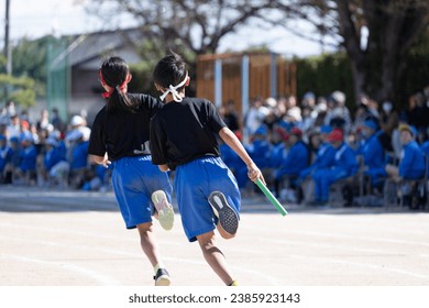 Elementary school boy running in relay at sports day - Powered by Shutterstock