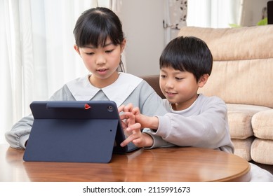 Elementary school boys and girls studying on tablets