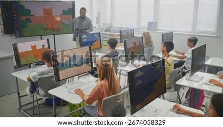 Elementary School Children Using Computers, Creating Digital Illustrations. African American Teacher Teaching Young Boys and Girls During Art Lesson Using Digital Screen. STEM Education. Static Shot.