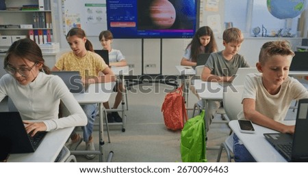 Elementary School Children Using Laptops, Doing Creative Tasks During Digital Art Lesson in Classroom. Digital Screen Showing AI Software for Creating Pictures. Interactive STEM Education. Dolly Shot.