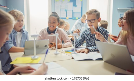 In the Elementary School: Class of Smart Young Children Work as a Team Using Tablet Computers to Program Wind Turbines. Classroom with Kids Learning about Eco-Friendly Forms of Renewable Energy - Powered by Shutterstock