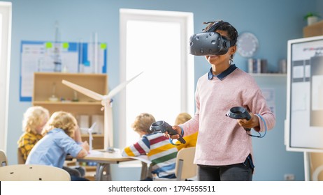 Elementary School Computer Science Class: Cute Girl Wearing Augmented Reality Headset and Using Controllers Learns Lessons in Virtual Reality Excited, Curious and Interested in Knowledge