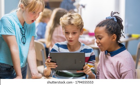 Elementary School Computer Science Class: Two Girls and Boy Use Digital Tablet Computer with Augmented Reality Software, They’re Excited, Full of Wonder, Curiosity. Children in STEM, Playing, Learning - Powered by Shutterstock