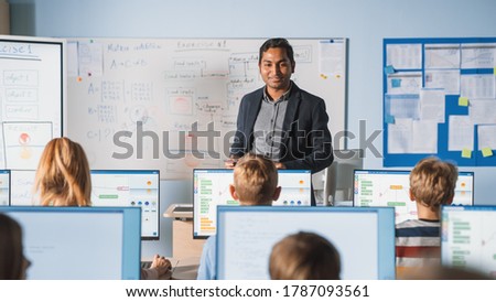 Elementary School Computer Science Class: Teacher Uses Digital Tablet, Explains Lesson to Diverse Group of Smart Children. Kids getting Modern Education, Learn Internet Safety, Software Programming