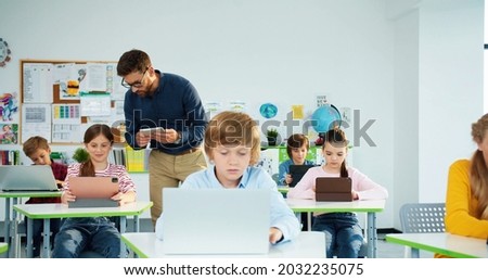 Similar – Image, Stock Photo Teacher explaining types of renewable energies in poster at ecology classroom
