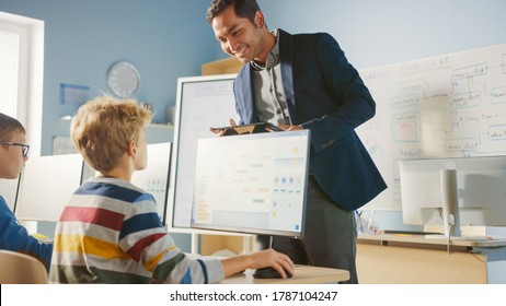 Elementary School Computer Science Classroom: Teacher Uses Tablet Computer, Explains Lesson to Diverse Group of Smart Children. Informatics Class for Children