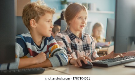 Elementary School Computer Science Classroom: Portrait of Smart Girl and Boy Talking while using Personal Computer, Learning Informatics, Internet Safety, Programming Language for Software Coding