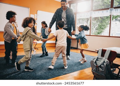 Elementary school fun. Teacher playing a game with his students in a classroom. Fun is a part of early child development. - Powered by Shutterstock