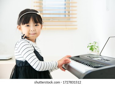Elementary school girl practicing the piano