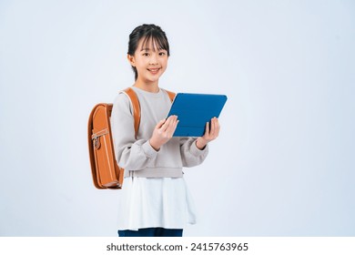 An elementary school girl using a smartphone. - Powered by Shutterstock