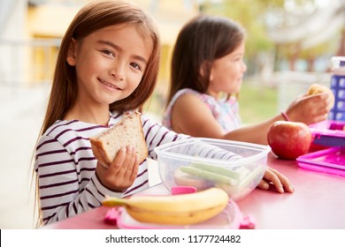 Elementary School Girls Eating At School Lunch Table