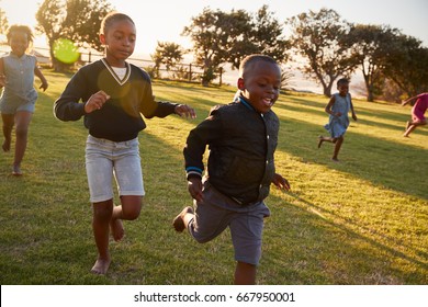 Elementary School Kids Running To Camera In An Open Field