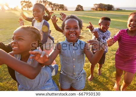Elementary school kids running to camera outdoors, close up
