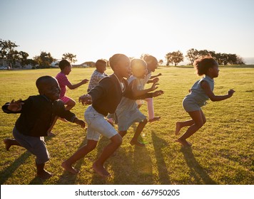 Elementary School Kids Running Together In An Open Field