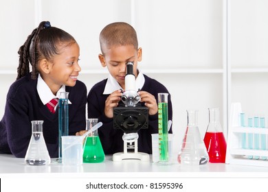 Elementary School Kids In Science Class Using A Microscope