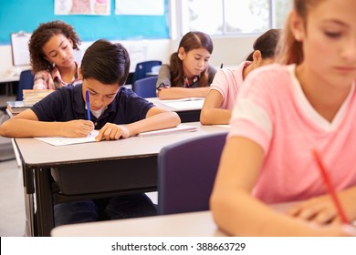 Elementary School Kids Working At Their Desks In A Classroom