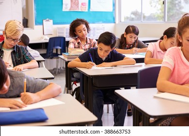 Elementary School Kids Working At Their Desks In A Classroom