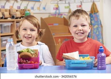 Elementary School Pupils With Healthy And Unhealthy Lunch Boxes