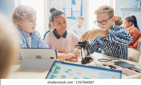 Elementary School Robotics Classroom: Diverse Group of Children Building and Programming Robot Together, Talking and Working as Team. Kids Learning Software Design and Creative Robotics Engineering - Powered by Shutterstock