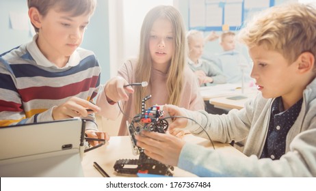 Elementary School Robotics Classroom: Diverse Group of Brilliant Children Building and Programming Robot, Talking and Working as a Team. Kids Learning Software Design and Creative Robot Engineering - Powered by Shutterstock