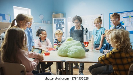 Elementary School Science / Chemistry Classroom: Enthusiastic Teacher Shows Funny Chemical Reaction Experiment To Group Of Children. Mixing Chemicals In Beaker So They Shoot Foam (Elephant Toothpaste)