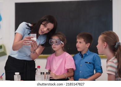 Elementary School Science Classroom: Enthusiastic Teacher Explains Chemistry to Diverse Group of Children, Little Boy Mixes Chemicals in Beakers. Children Learn with Interest - Powered by Shutterstock