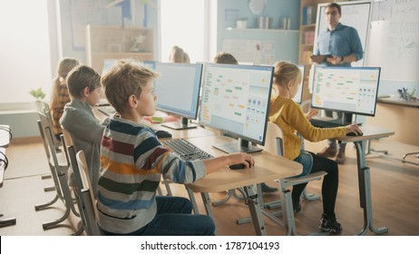 Elementary School Science Classroom: Teacher Educates Smart Little Schoolchildren who Work on Personal Computers Learn Programming Language for Software Coding. Schoolchildren Getting Modern Education
