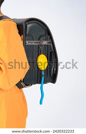 Elementary school student with security buzzer attached to school bag