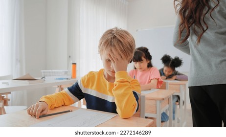 Elementary school students boy are stressing about doing their final exams in the exam room at school - Shutterstock ID 2272146289