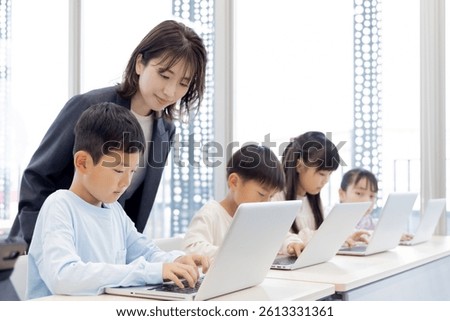 Elementary school students learning how to use a laptop
