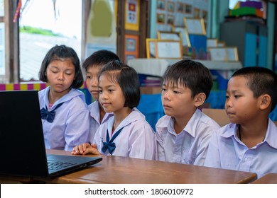 Elementary school students looking at computer in classroom,education,learning and people concept.