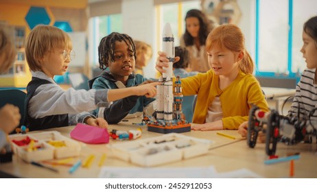 Elementary School Students Sitting Behind a Table in a Group, Building a Space Rocket Model for a Science and Technology Fair. Young Boys and Girls Wish to Become Engineers and Space Explorers - Powered by Shutterstock