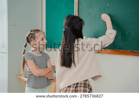 Elementary school students solving math problems on chalkboard in classroom, active learning and childhood education concept with teamwork, Back to school