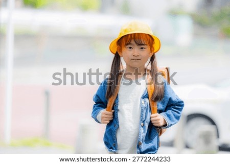 Elementary school students walking to school with their backpacks on; a smiling image promoting traffic safety on the way to school,looking at camera