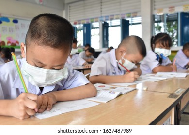 Elementary School Students Wearing Hygienic Mask While Studying In The Classroom.