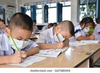 Elementary School Students Wearing Hygienic Mask While Studying In The Classroom.