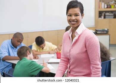 Elementary School Teacher With Pupils In Background