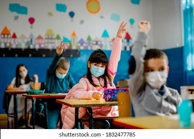 Elementary schoolchildren wearing a protective face masks  in the classroom. Education during epidemic. - Powered by Shutterstock