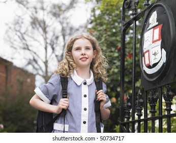 Elementary Schoolgirl Standing By School Gate