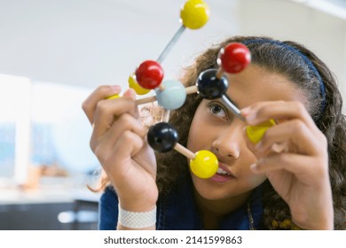 Elementary student examining molecule model - Powered by Shutterstock